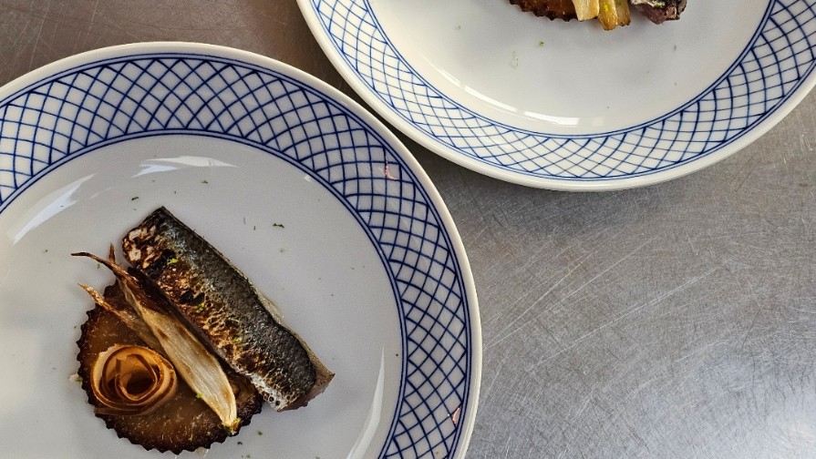 Whole grilled mackerel on blue-rimmed porcelain